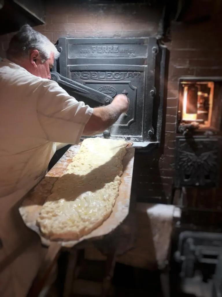 Enfornant el pa al forn de llenya de l'obrador